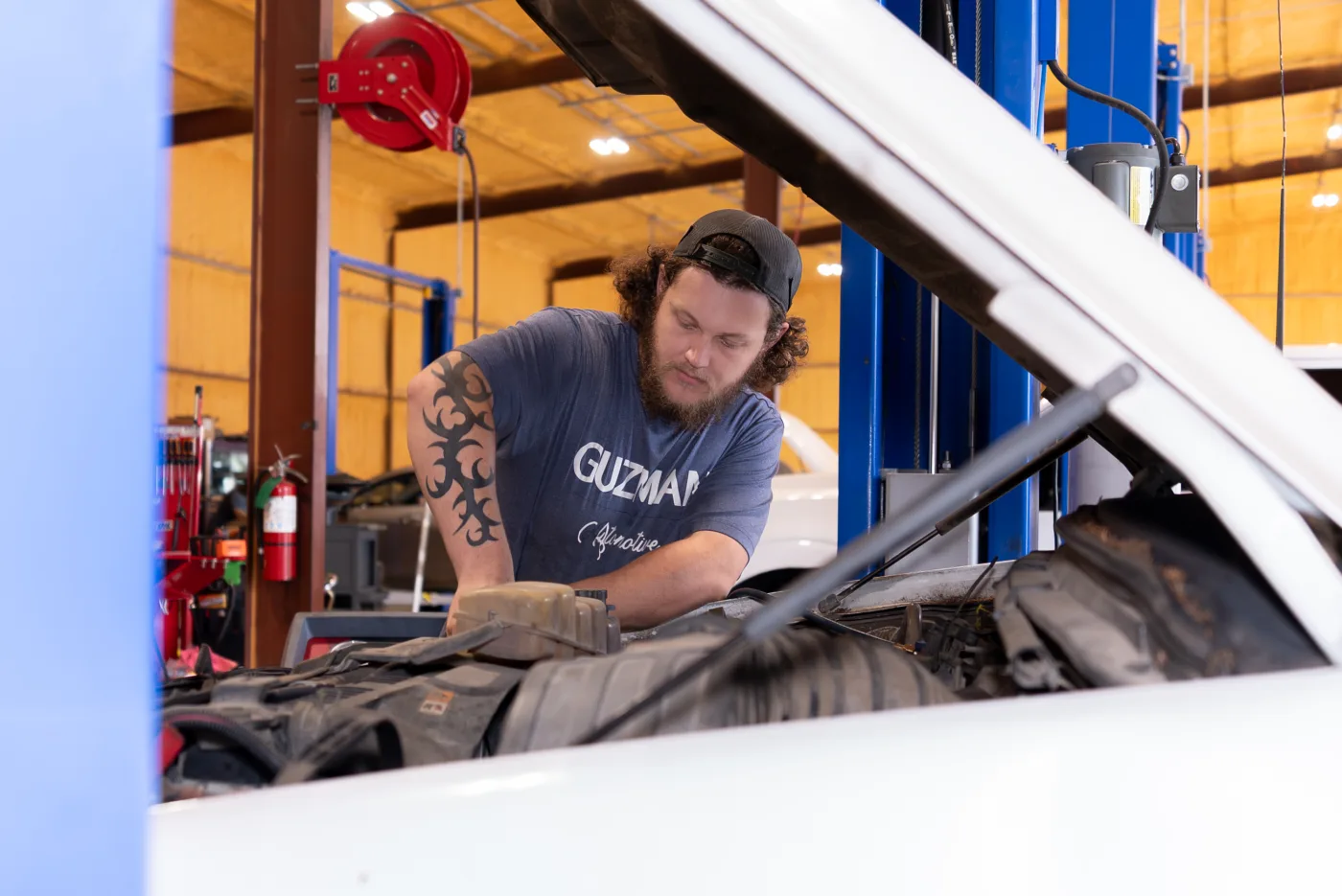 Guzman Automotive technician working under the hood on an A/C system